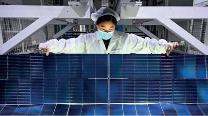 Trabajadora asiática de la industria fotovoltaica (FV) operando sobre un módulo solar en una fábrica